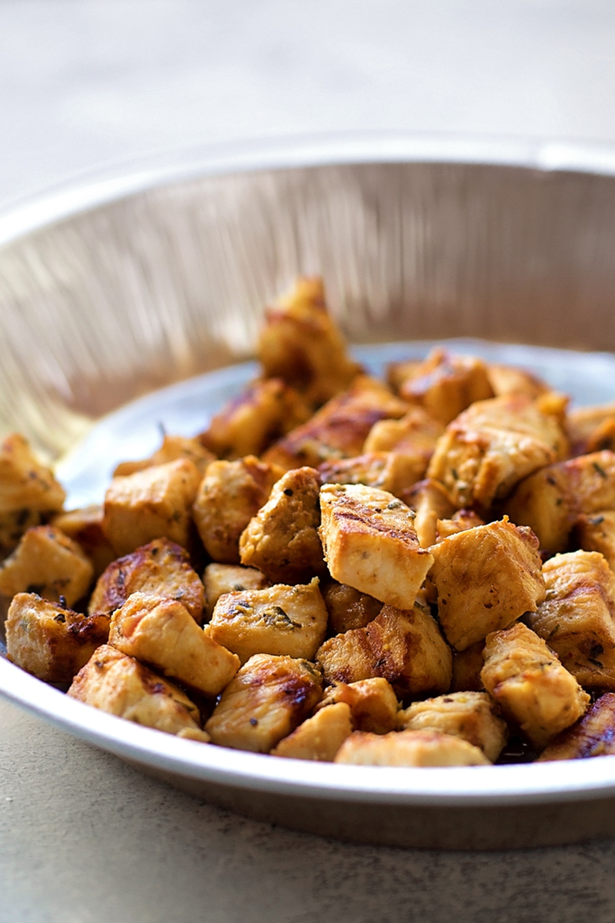 Bowl of diced grilled chicken pieces.
