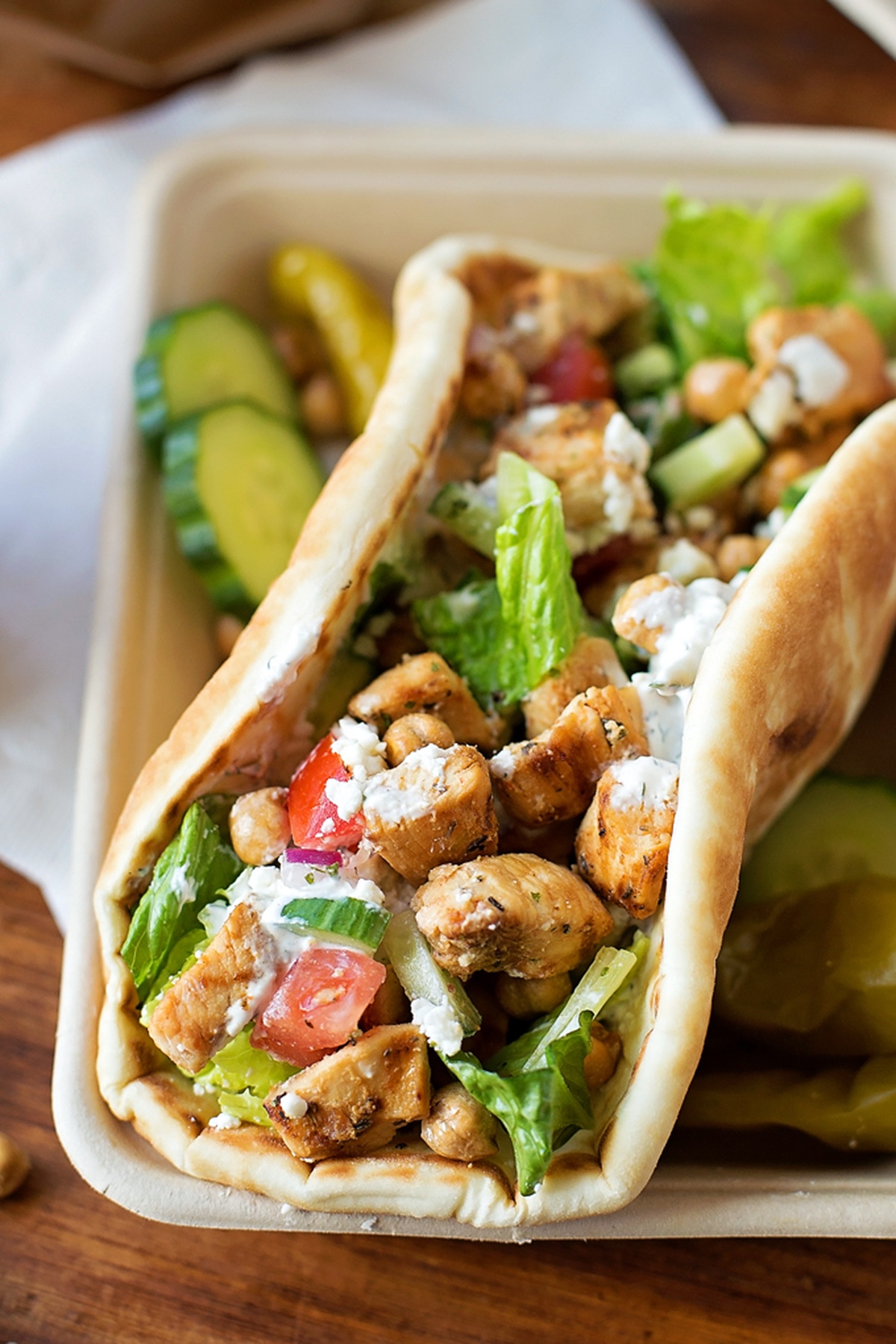 Grilled easy chicken pita served with sliced cucumbers and pickles.