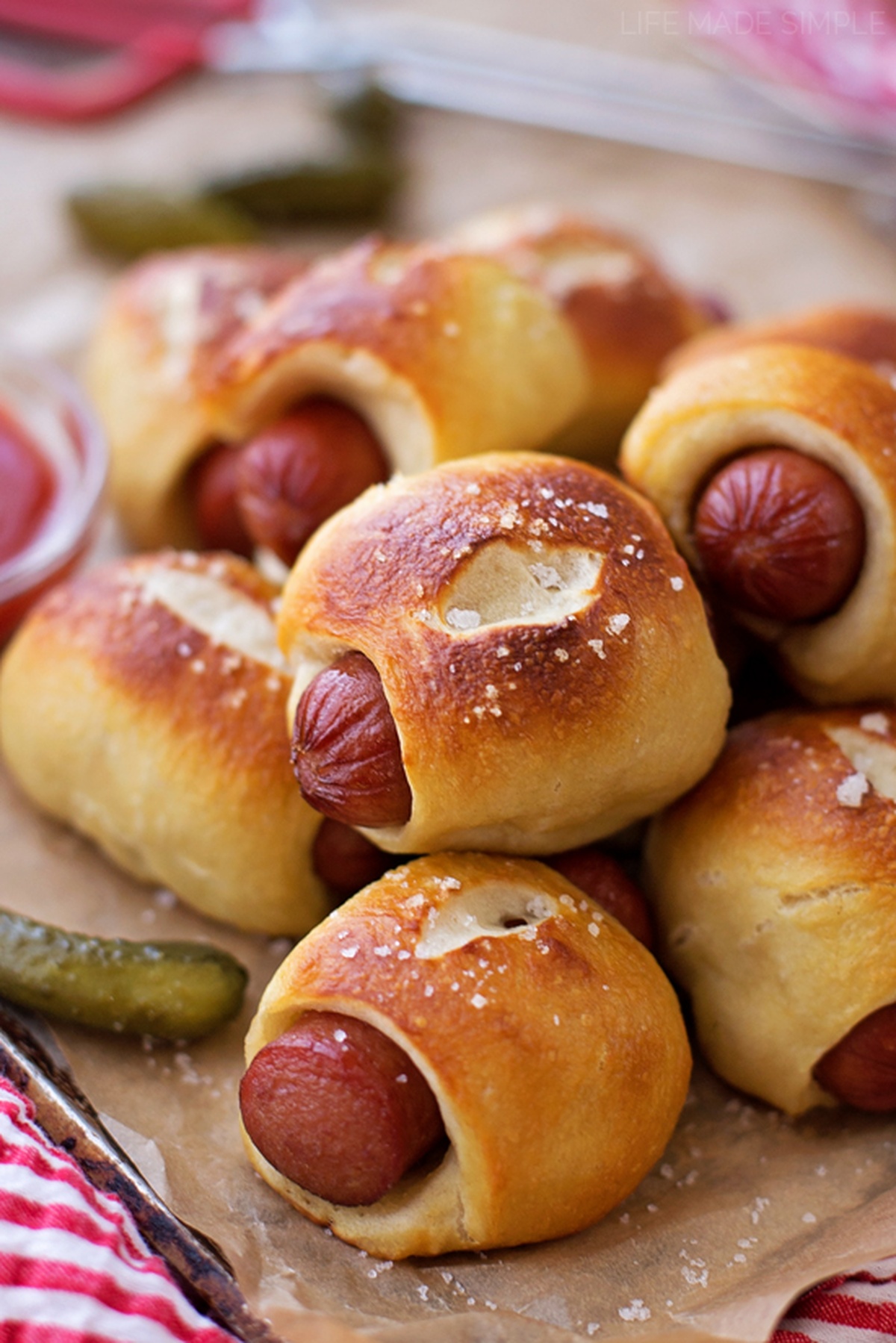 A close-up of mini pretzel dogs with a sprinkle of salt.