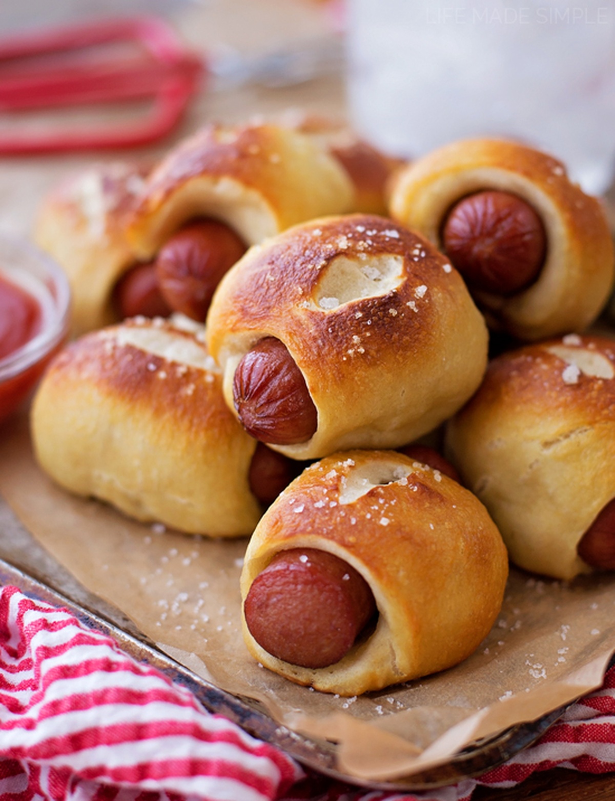 A close-up of mini pretzel dogs with a sprinkle of salt.