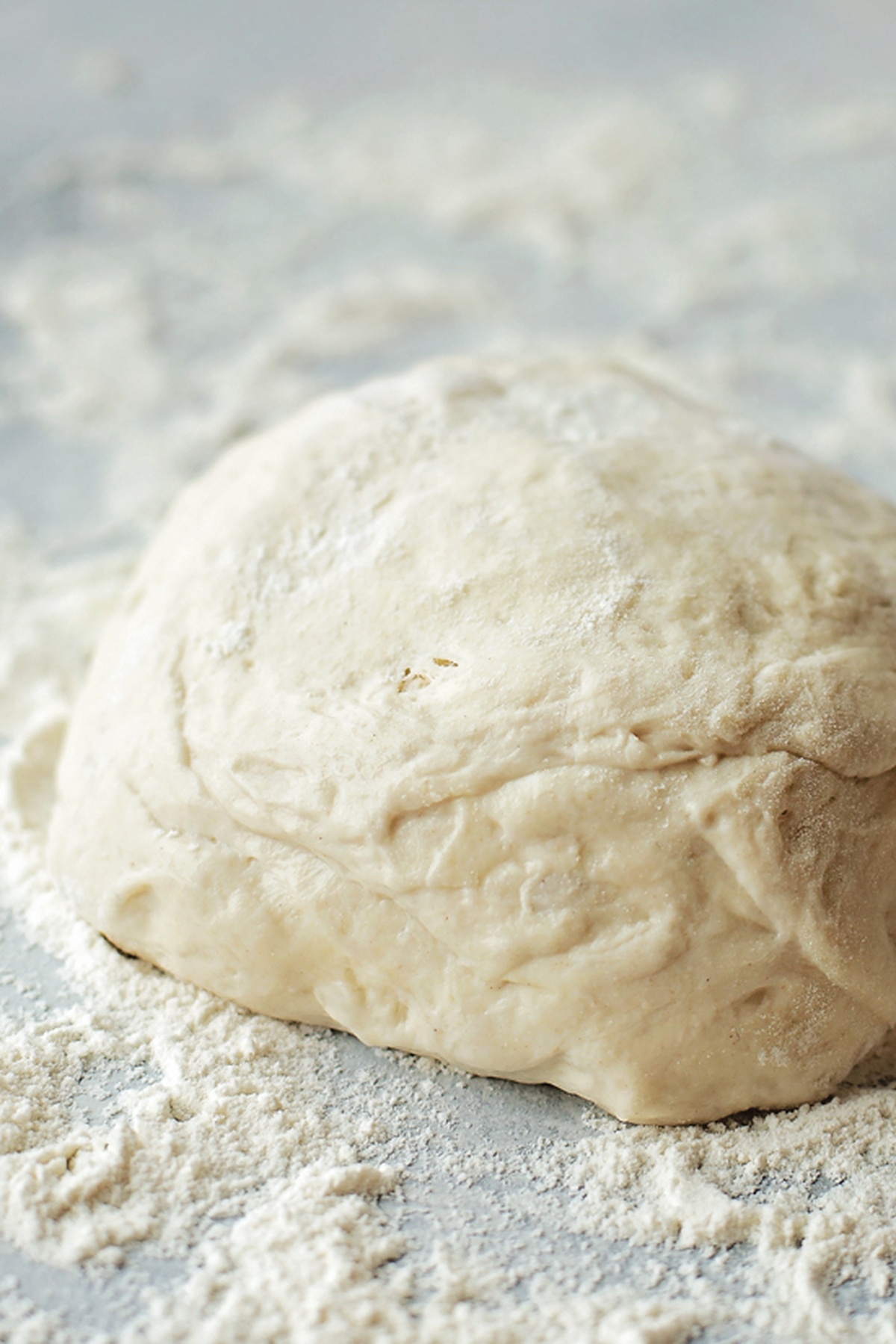 Dough ball ready for rolling, lightly dusted with flour.