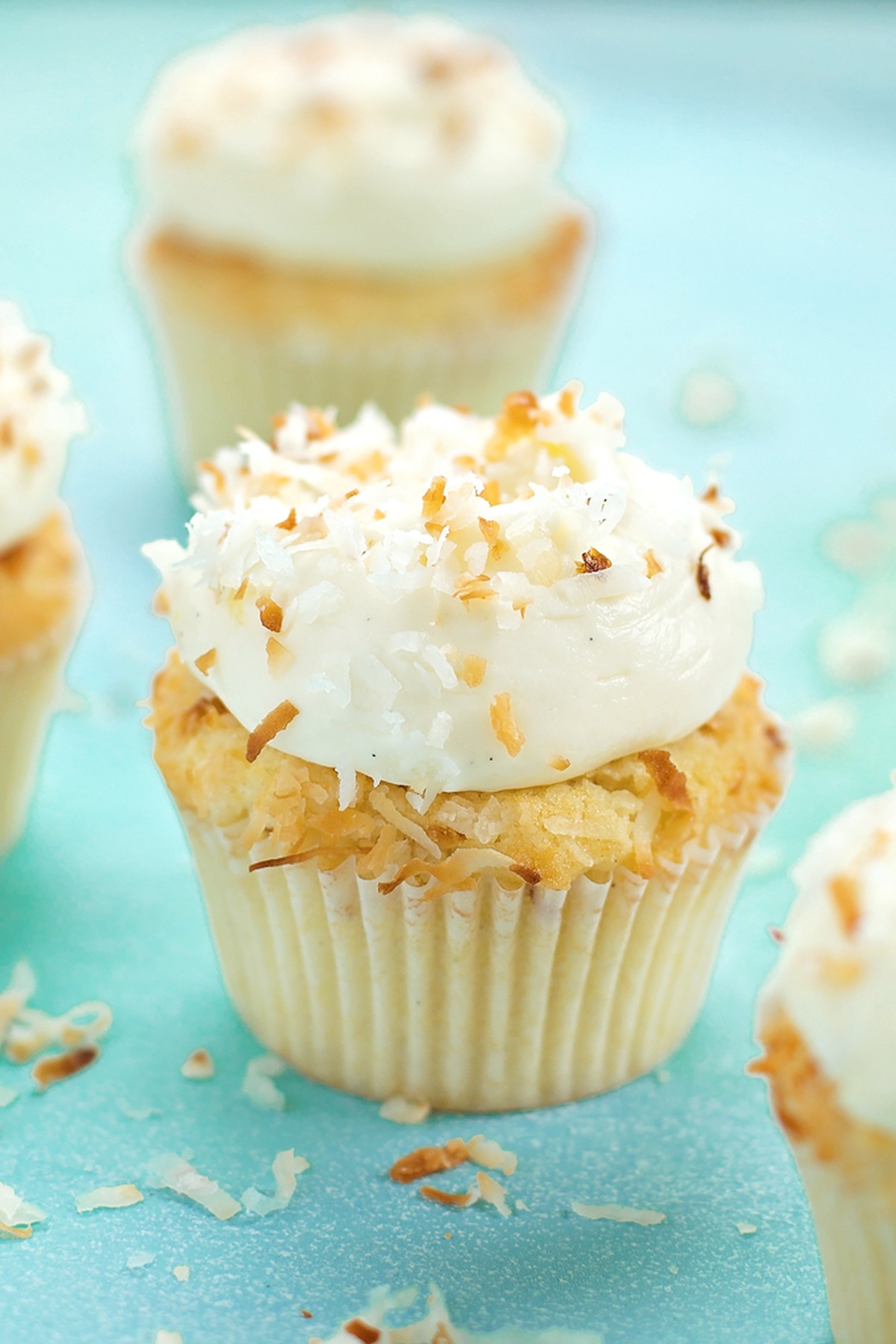 A Pina Colada cupcake with a cherry, pineapple, and a mini umbrella.