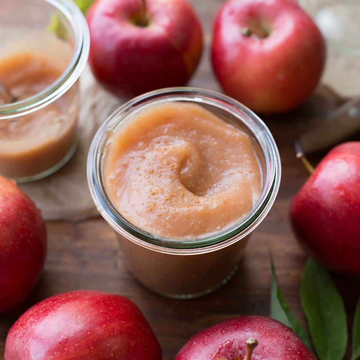 A jar filled with creamy unsweetened applesauce.