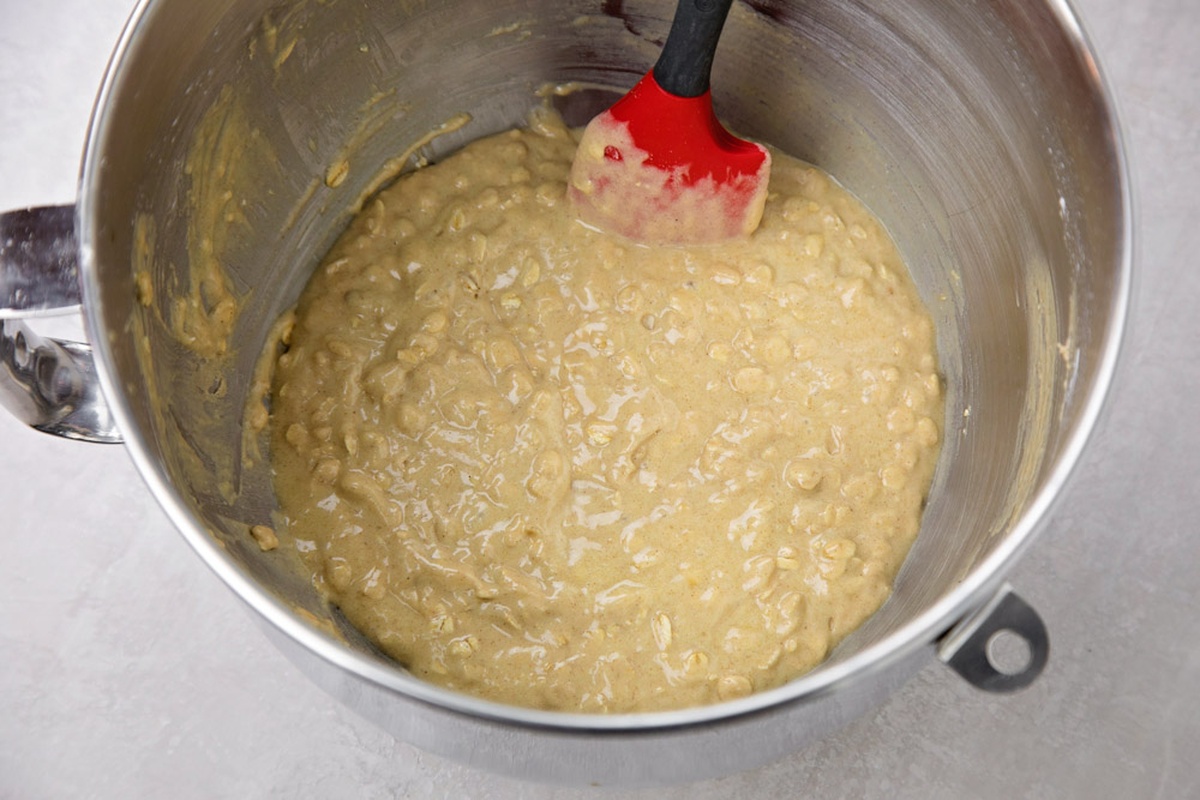 Batter for oatmeal crumb muffins in a mixing bowl with a spatula.