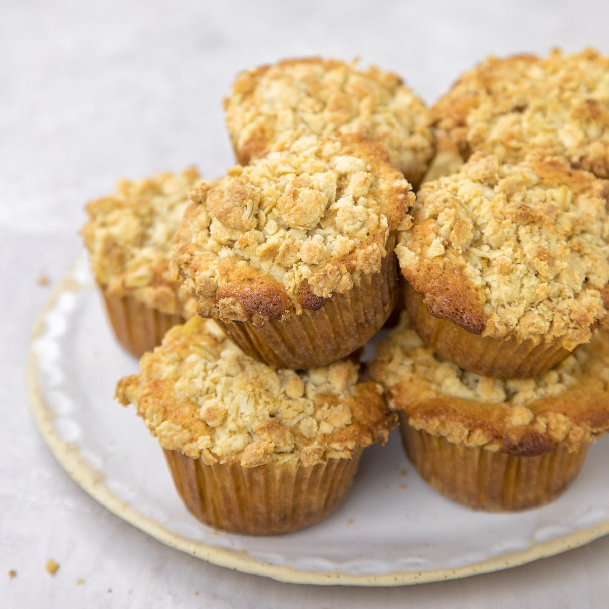 Close-up of oatmeal crumb muffins on a white plate.