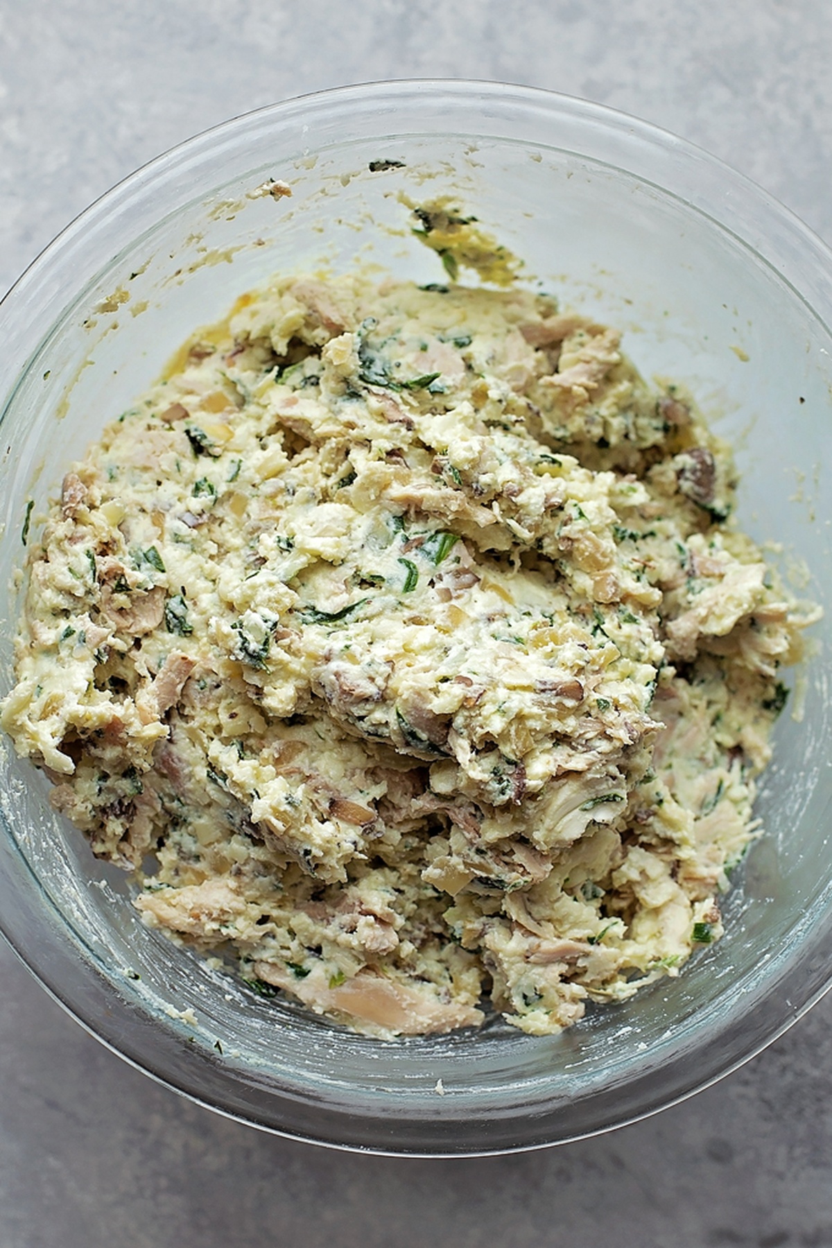 A bowl of chicken, spinach, and mushroom filling for lasagna.