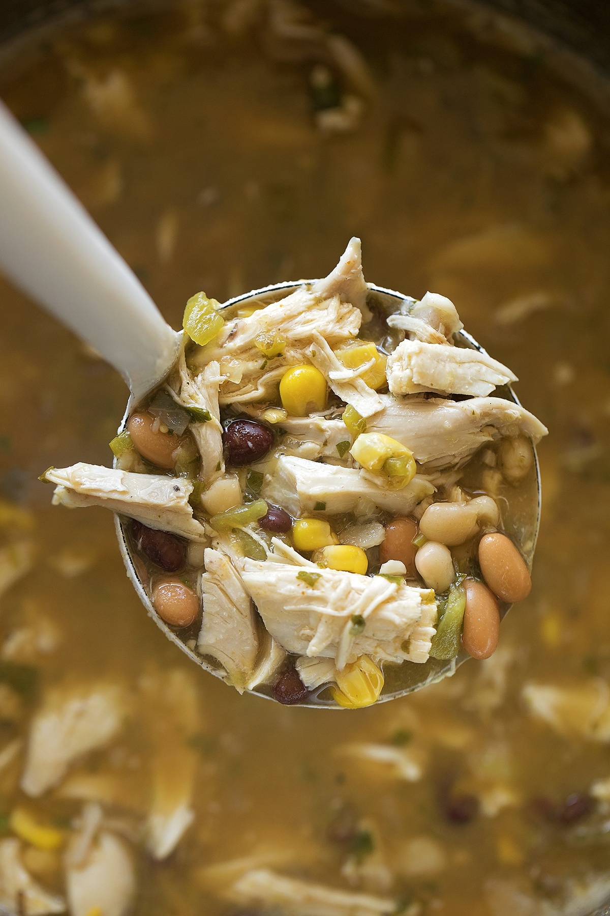 A ladle filled with jalapeno lime chicken soup.