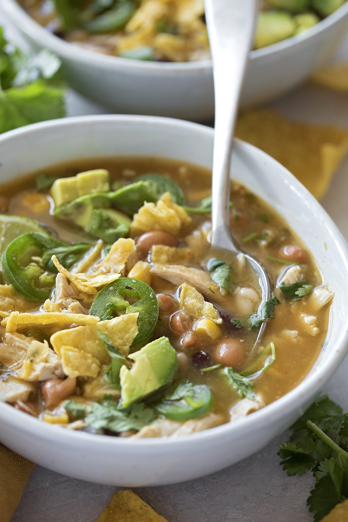 A bowl of jalapeno lime chicken soup with toppings.