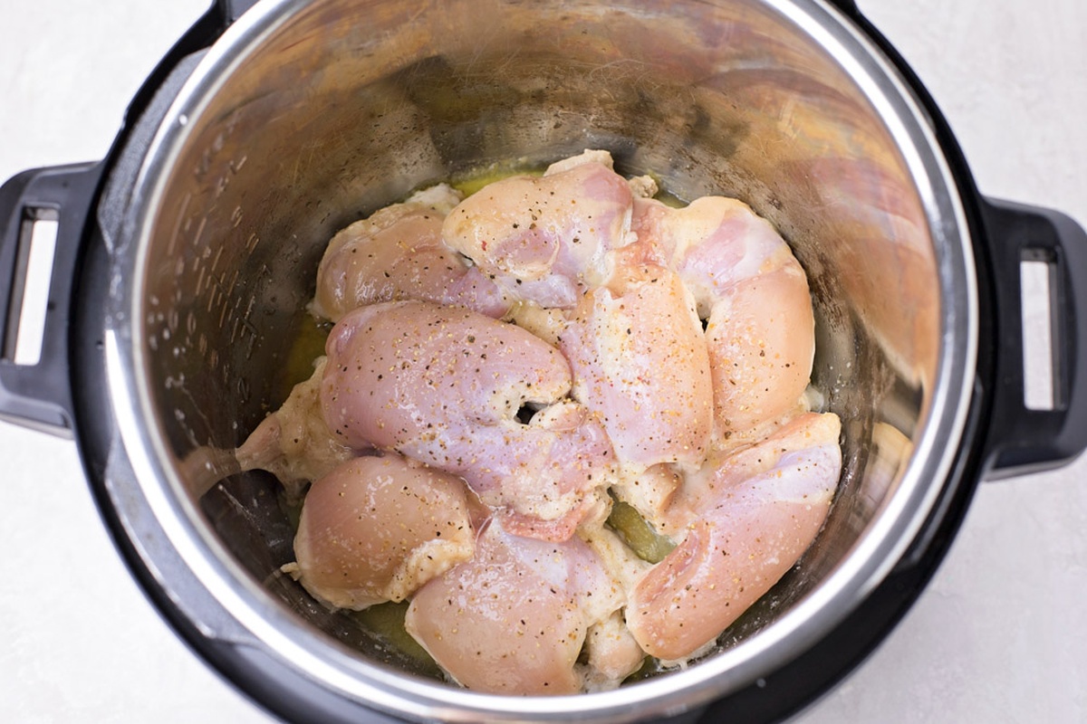 Raw chicken thighs seasoned and placed in an Instant Pot.