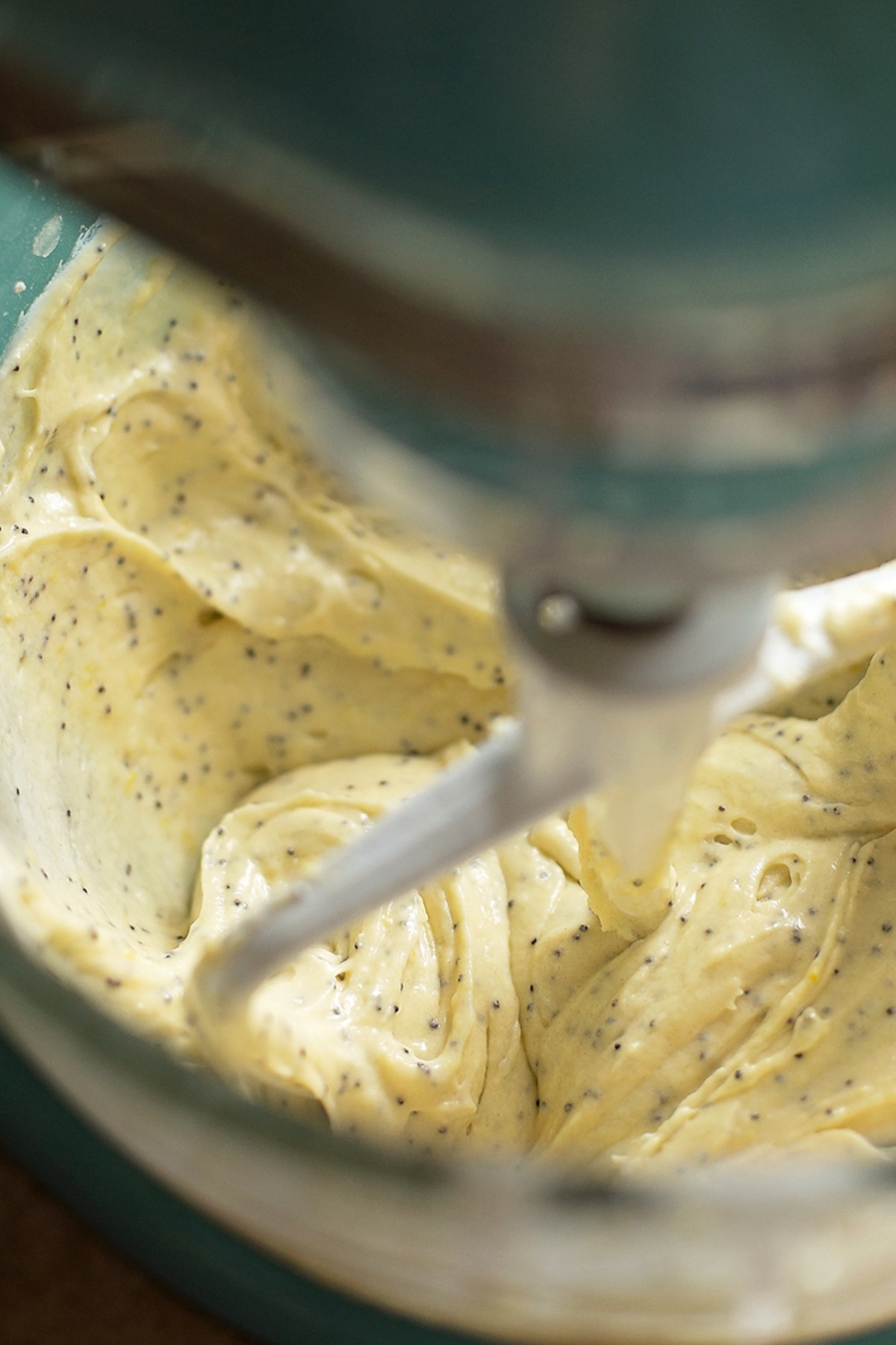 Lemon poppy seed batter being mixed in a stand mixer.