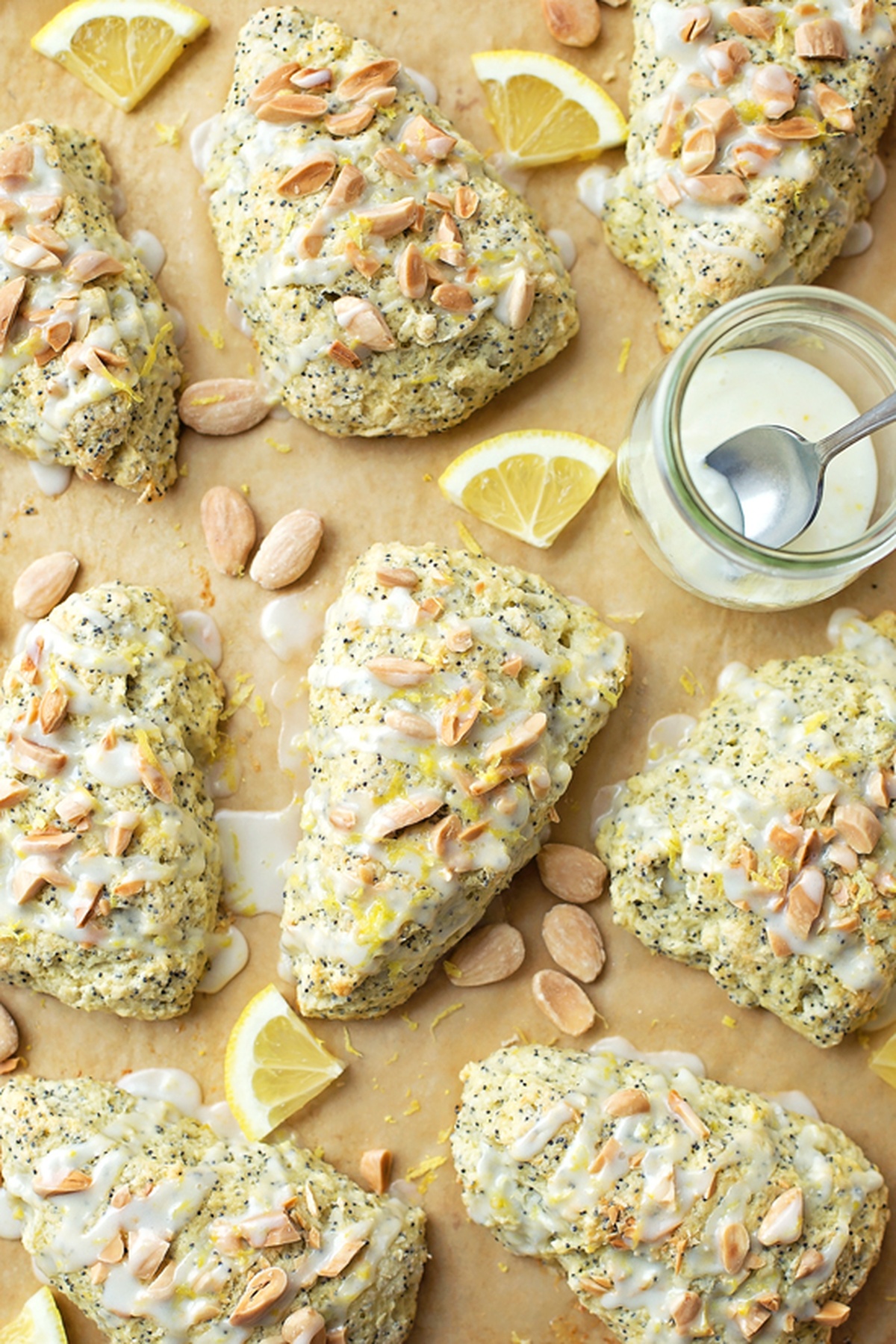 A batch of lemon almond poppy seed scones spread out on parchment paper.