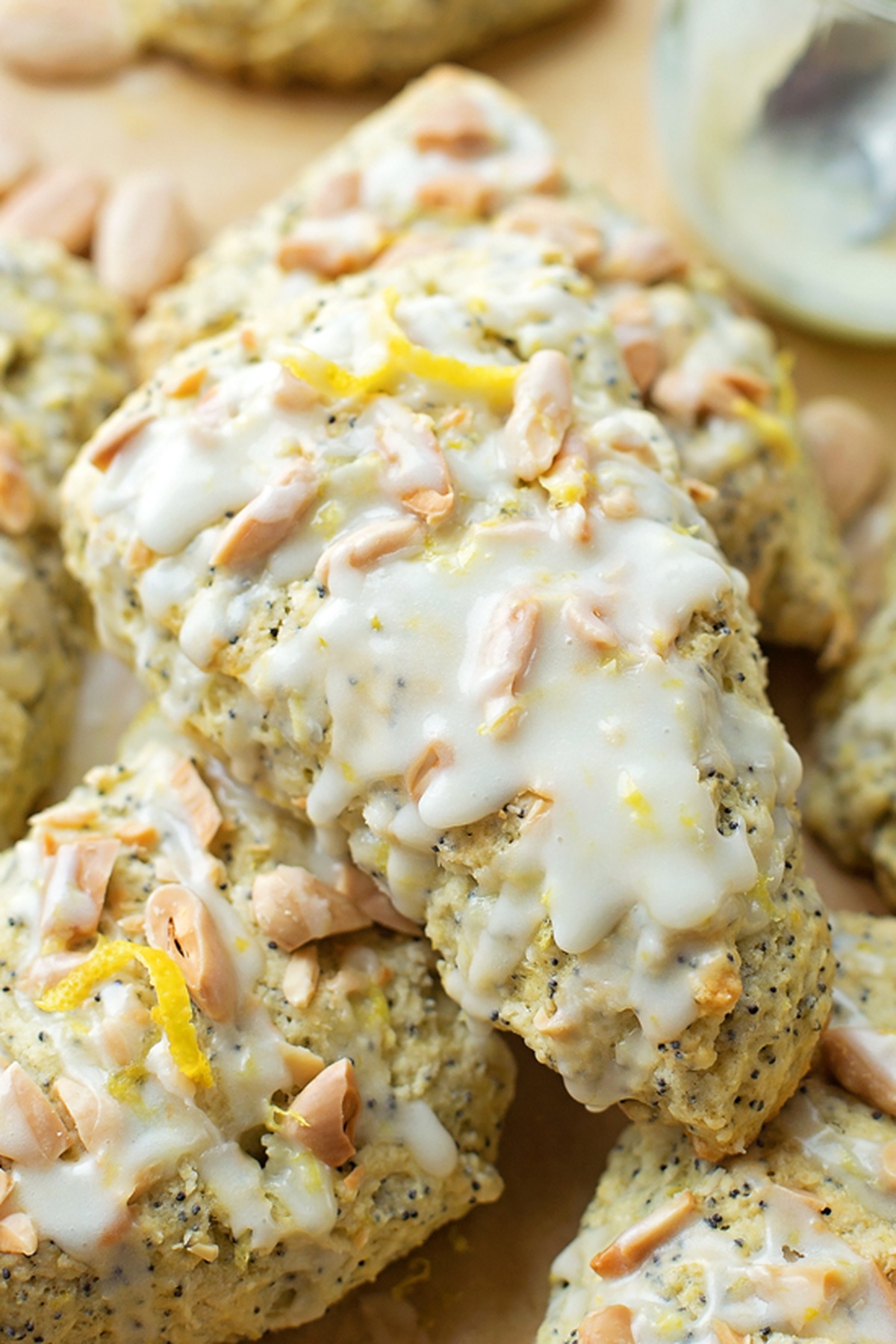 Close-up of scones topped with lemon zest, almonds, and glaze.