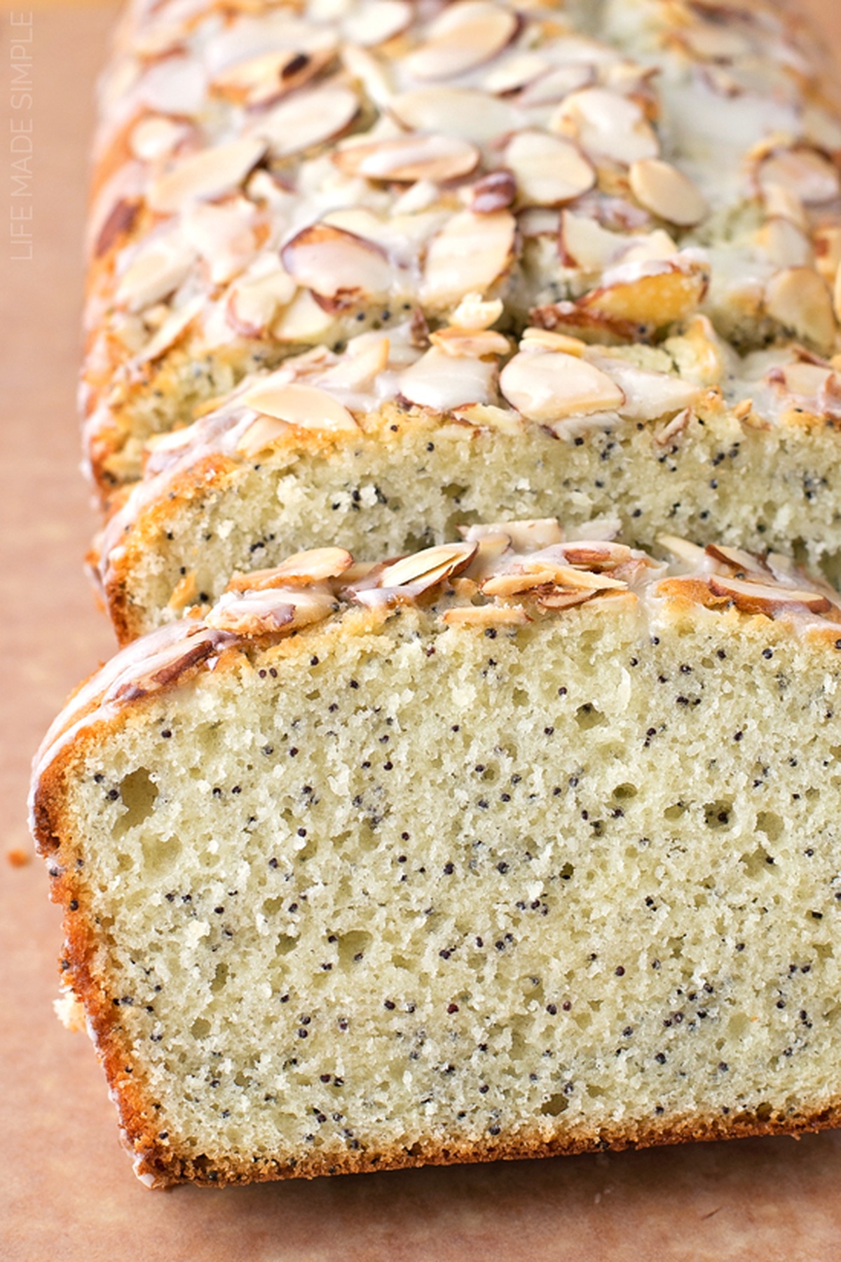 Sliced almond poppy seed loaf resting on a surface.