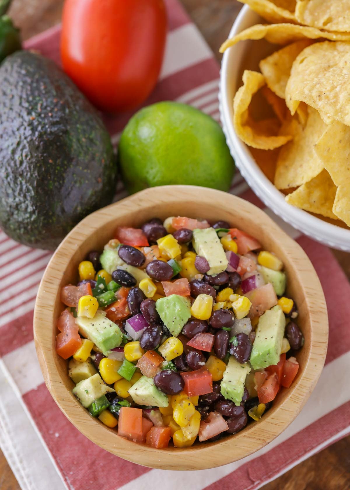 Avocado black bean and corn salsa in a wooden bowl.