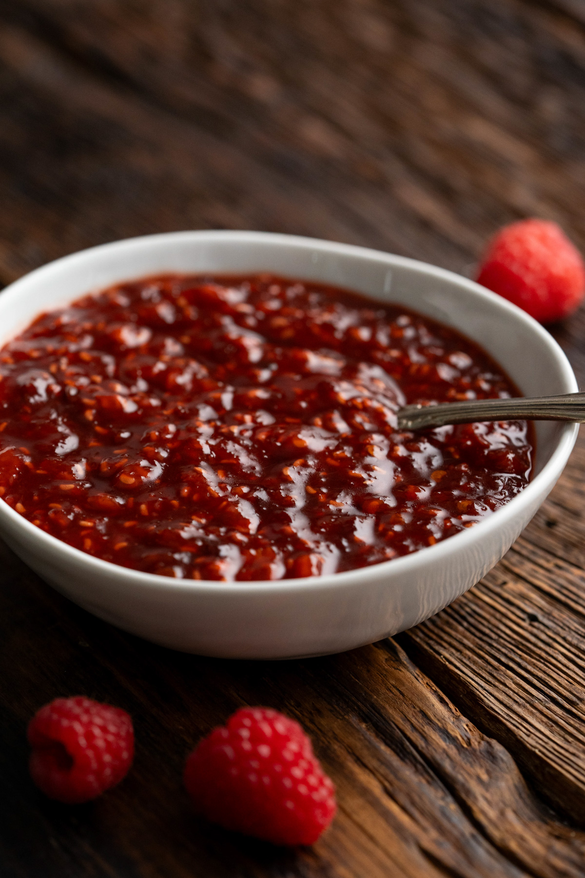 A bowl of raspberry chipotle sauce with a spoon in it.