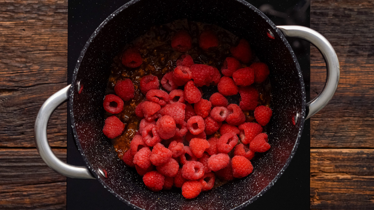 Raspberries added into the saucepan.