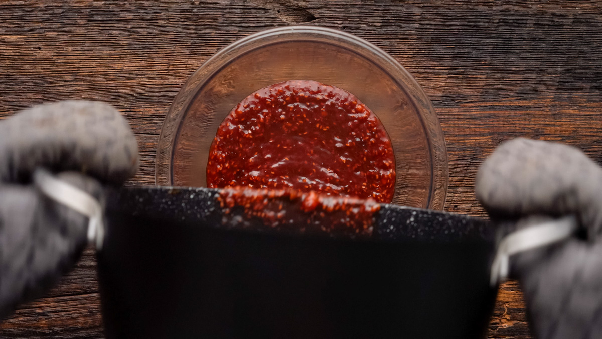 Pouring the raspberry chipotle sauce into a heat safe bowl. 