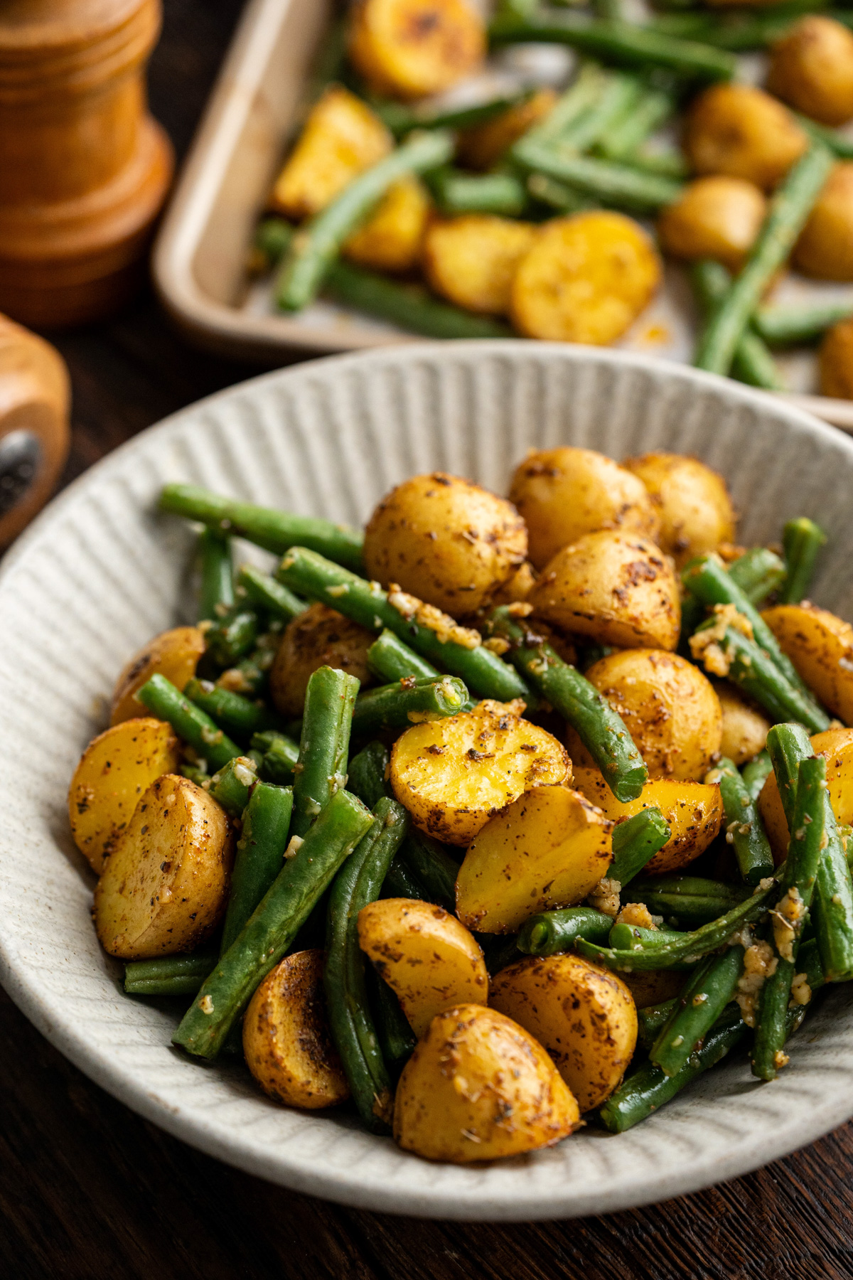 Potatoes and green beans in a white bowl.