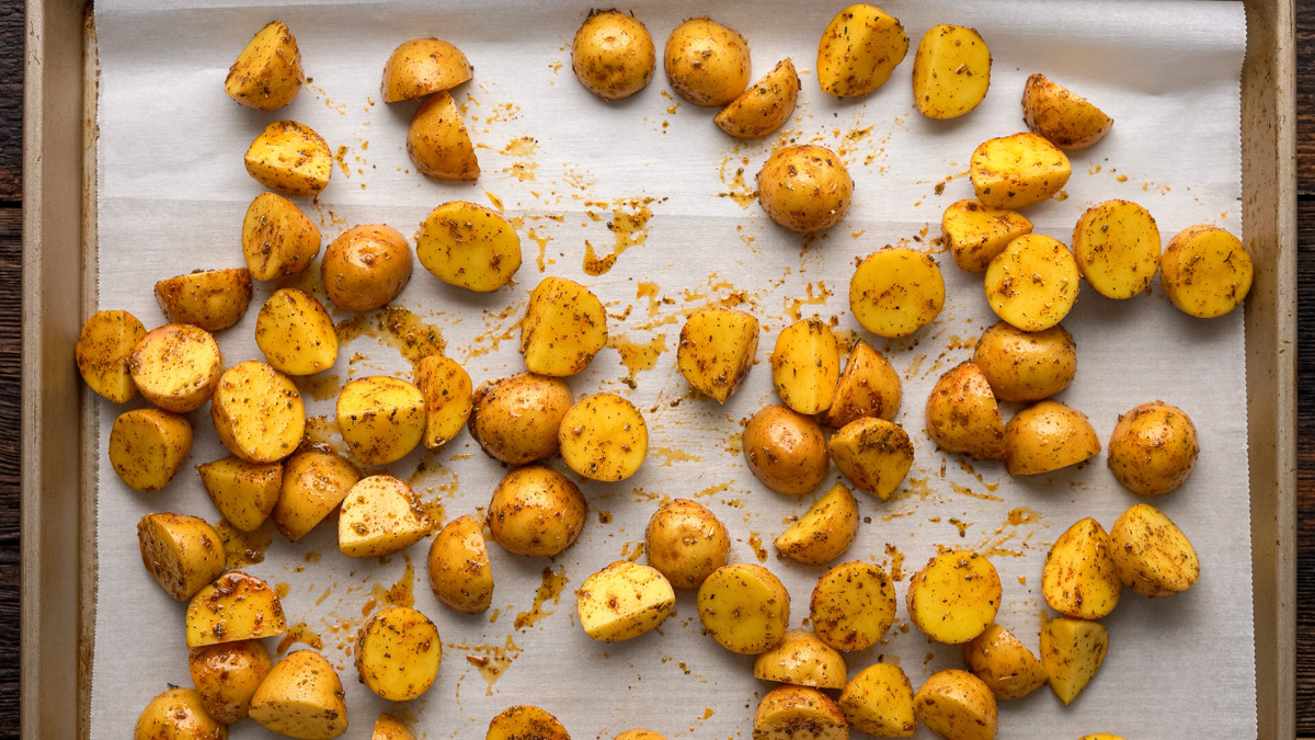 Potatoes added to a baking sheet.
