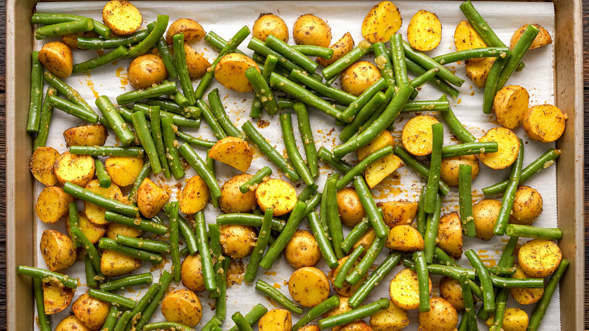 Green beans and potatoes on a baking sheet.