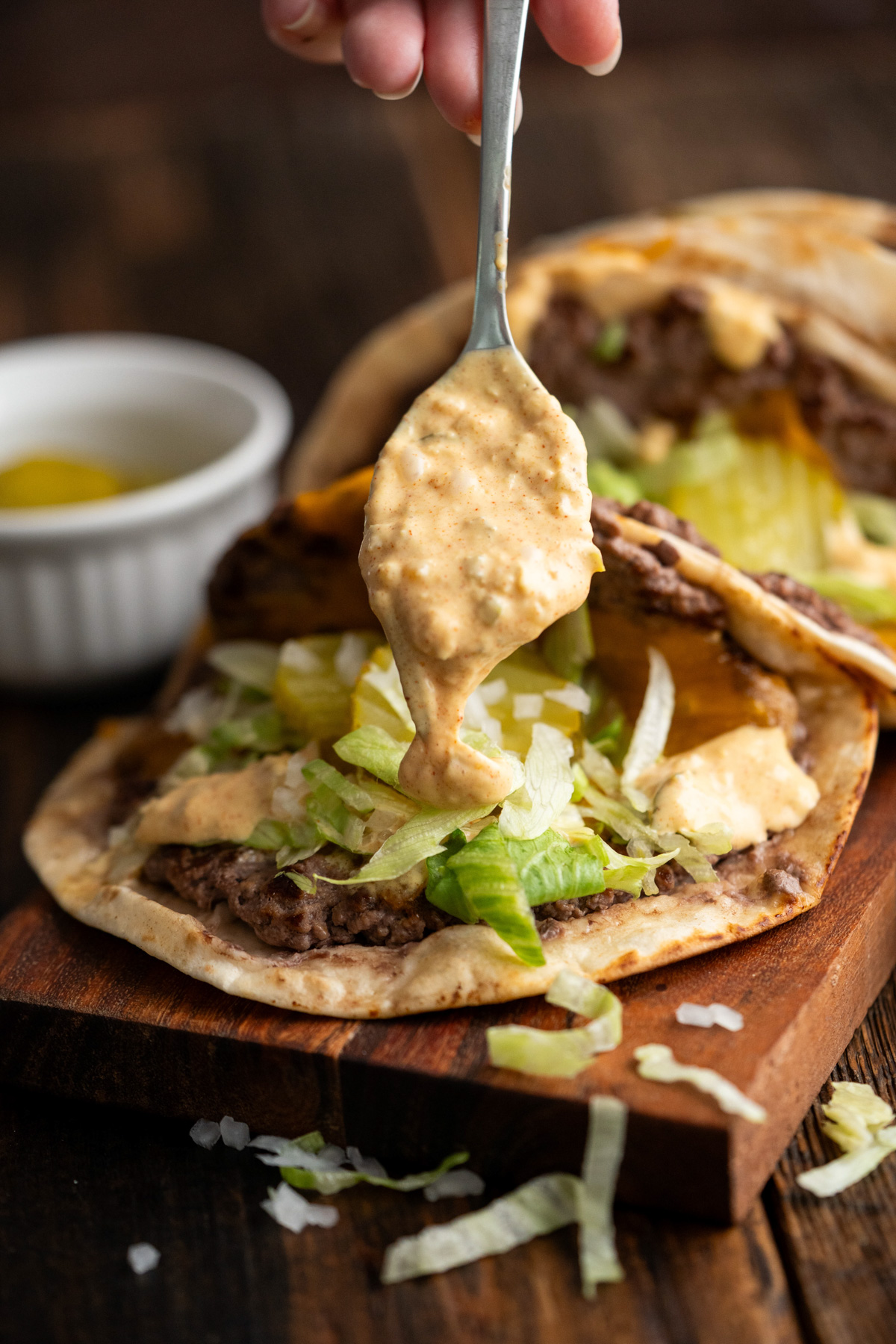 Big mac sauce being spooned onto a taco.