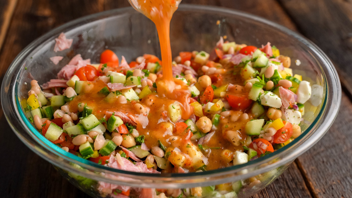 Dressing being poured over the salad.