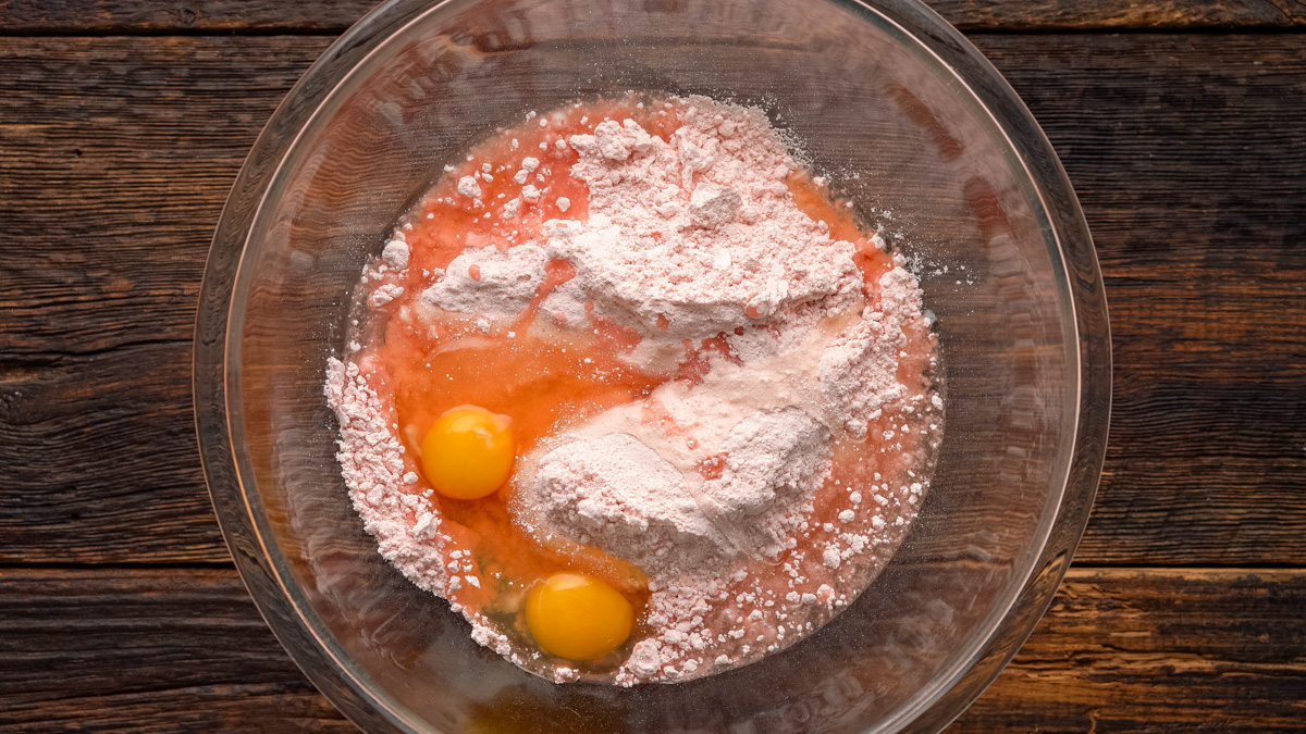 Cake mix, oil, and eggs in a glass bowl.