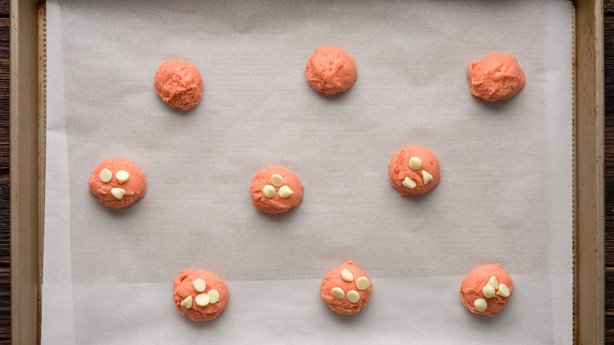 Cookie dough balls on a baking sheet before baking.