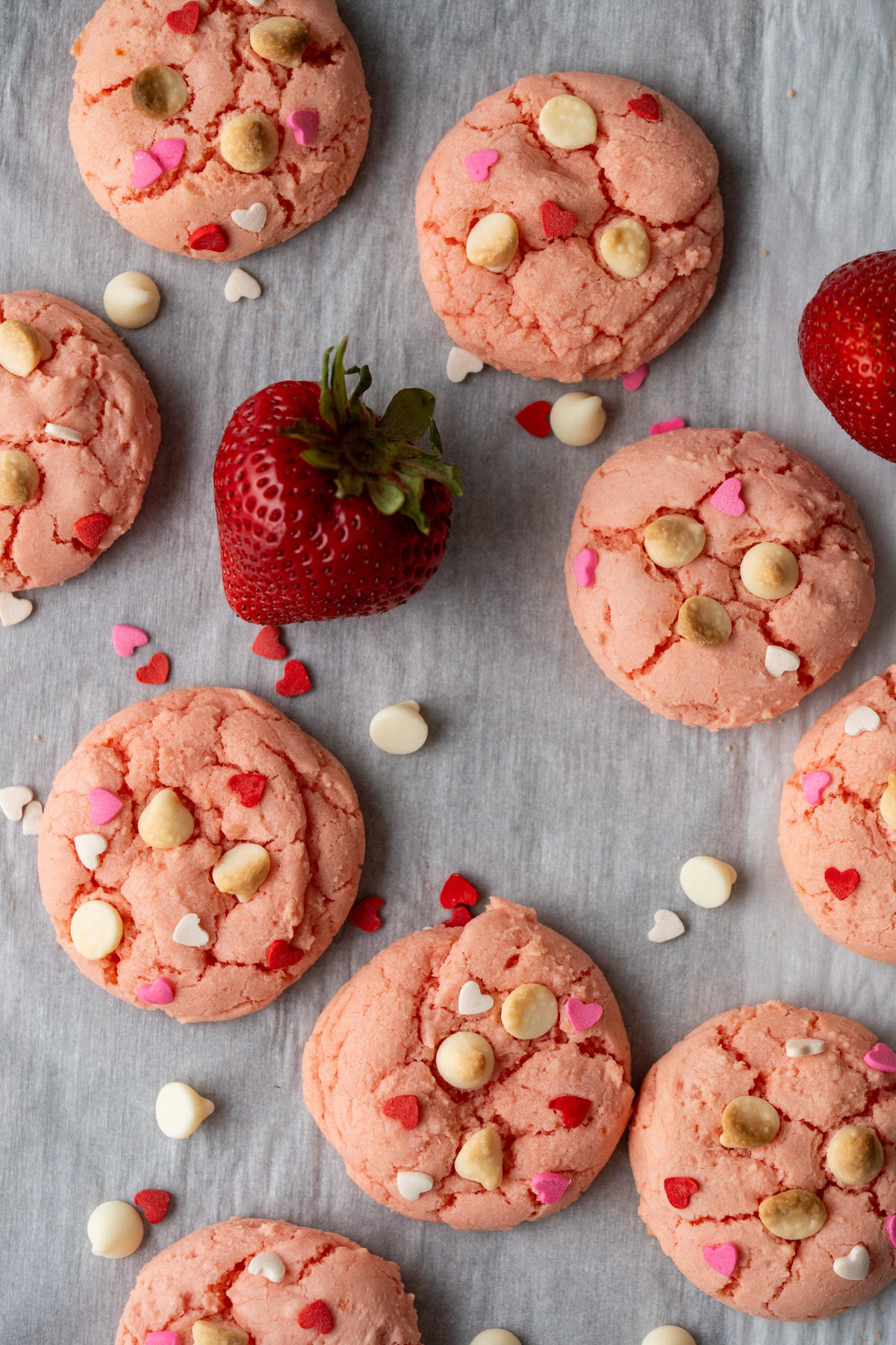 Strawberry cake mix cookies on white parchment paper.
