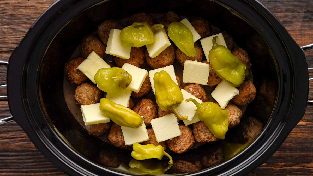 Butter and pepperoncinis added to the slow cooker.
