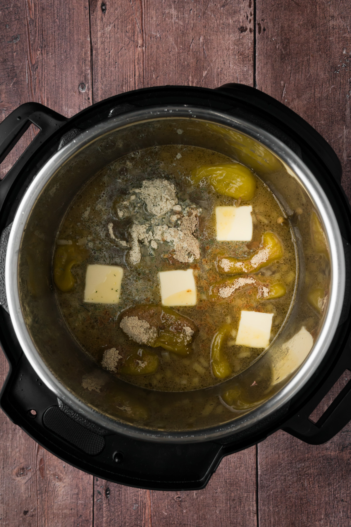 Seasonings, butter, and pepperoncini added to the Instant pot.