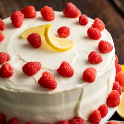 Brighten your day with this Lemon Raspberry Cake! Soft lemon cake layers packed with bursts of fresh raspberries and coated in a smooth buttercream frosting.
