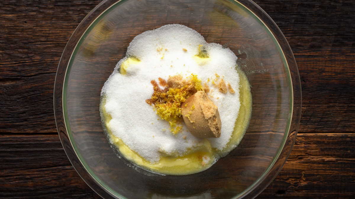 Buter, sugars, lemon zest, lemon extract, and vanilla in a glass bowl.