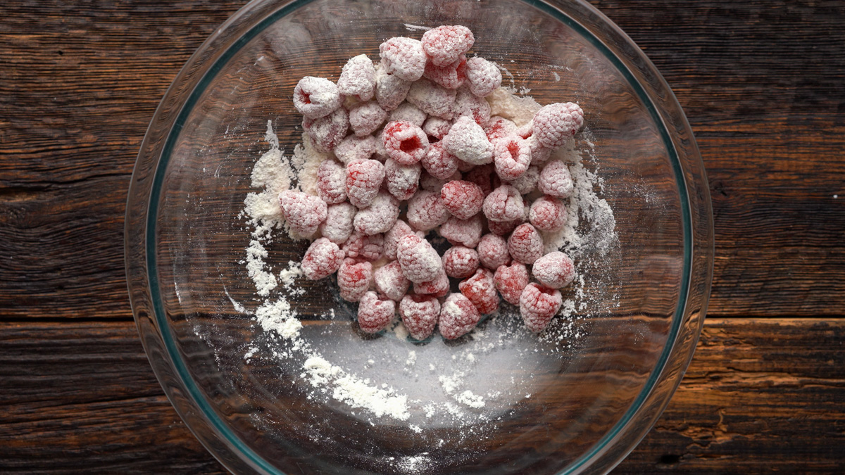Raspberries tossed in flour in a glass bowl.