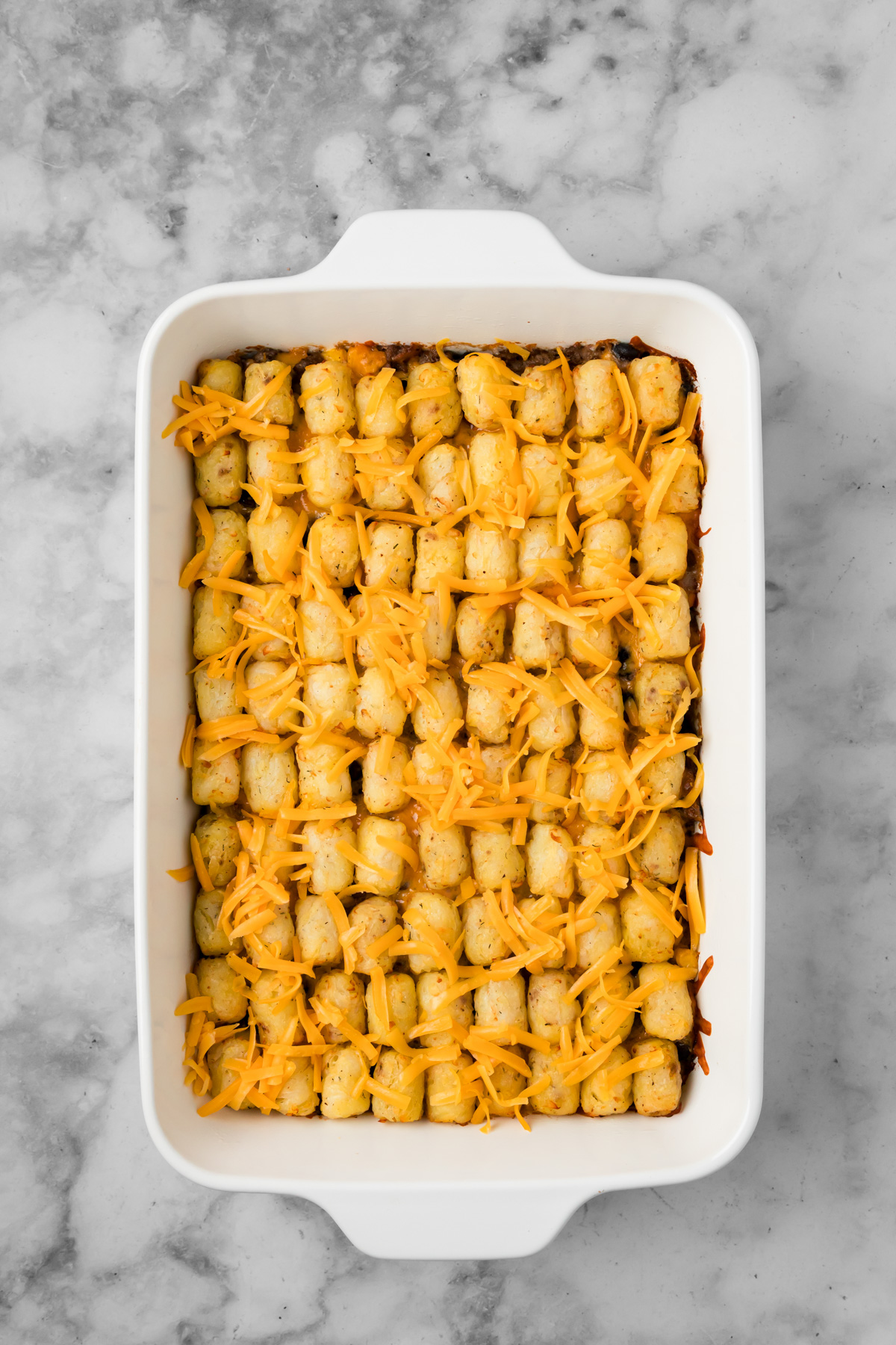 Shredded cheese added on top of the tater tots before the casserole finishes baking.