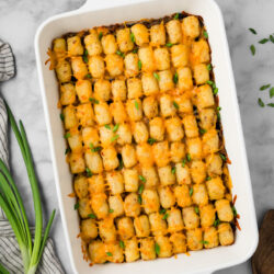 Finish your day with a healthy serving of this Cowboy Casserole recipe. It's a hearty dish filled with ground beef, corn, beans, and topped with crispy tater tots.