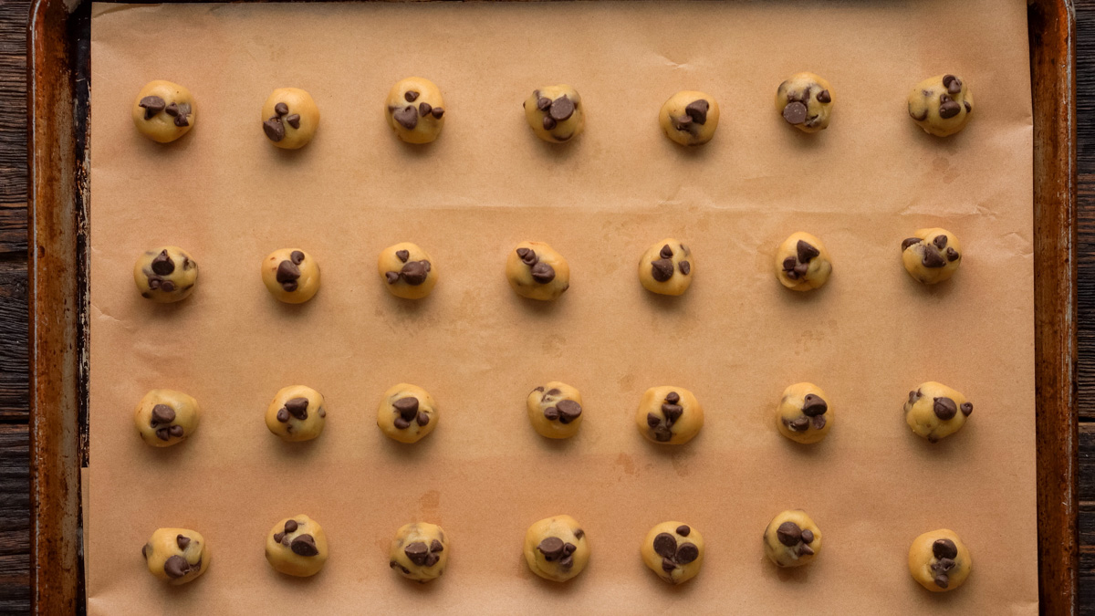 Cookie dough balls on a baking sheet before baking.