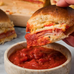 These Italian Sliders are loaded with deli meat, melty cheese, and peppers and then topped with a garlic butter sauce that everyone will love!