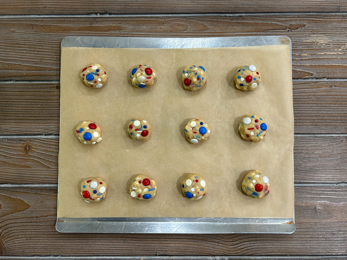 Cookie dough balls on a baking sheet.