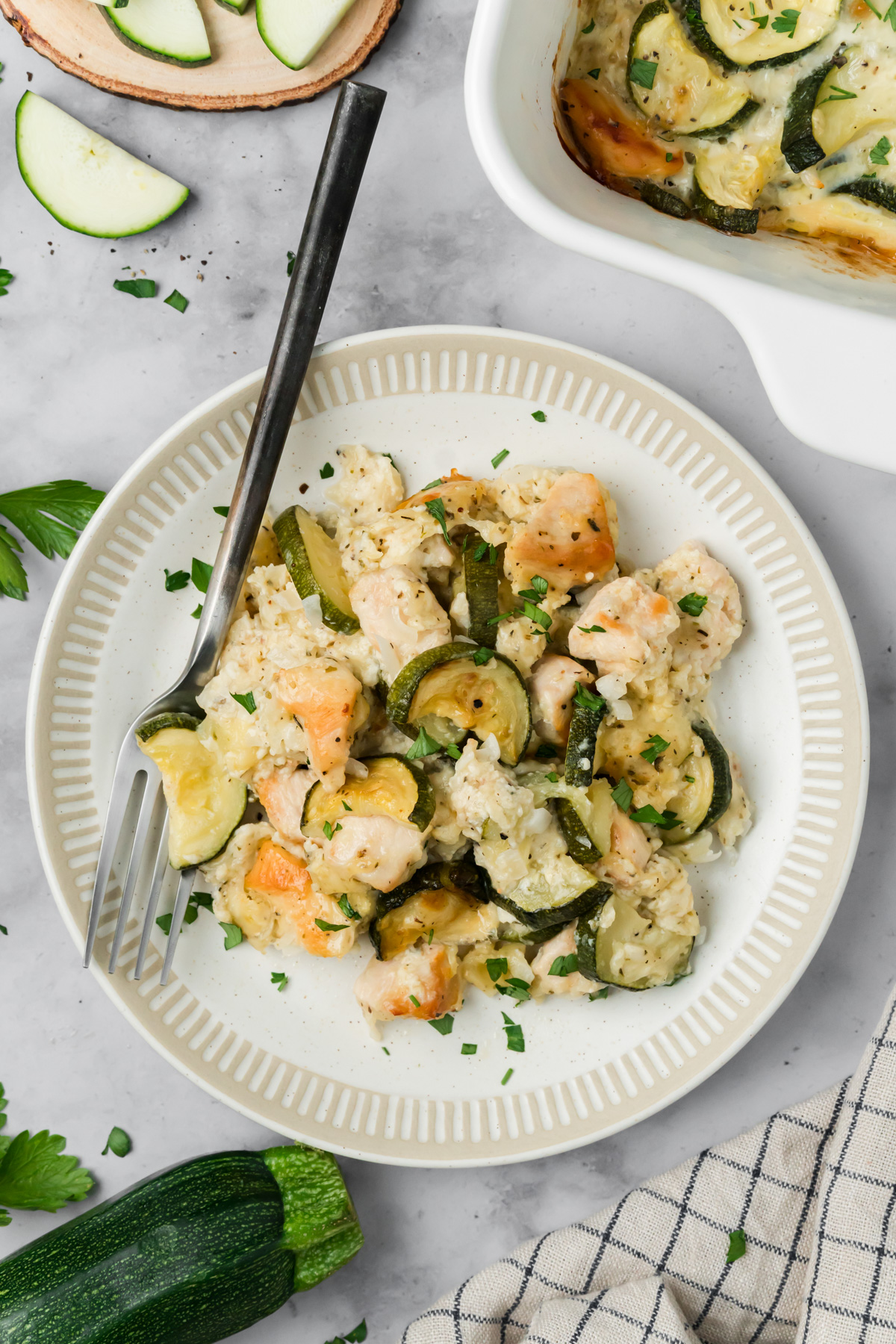 Serving of chicken zucchini bake on a white plate.