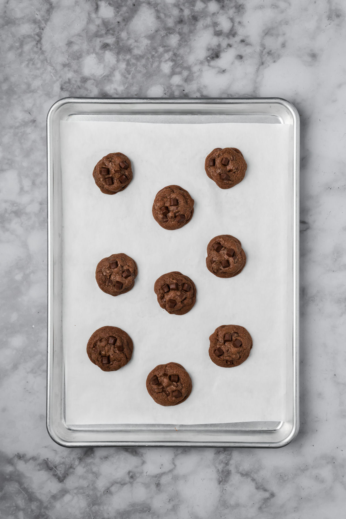 Dark chocolate cookies on a baking sheet after baking. 