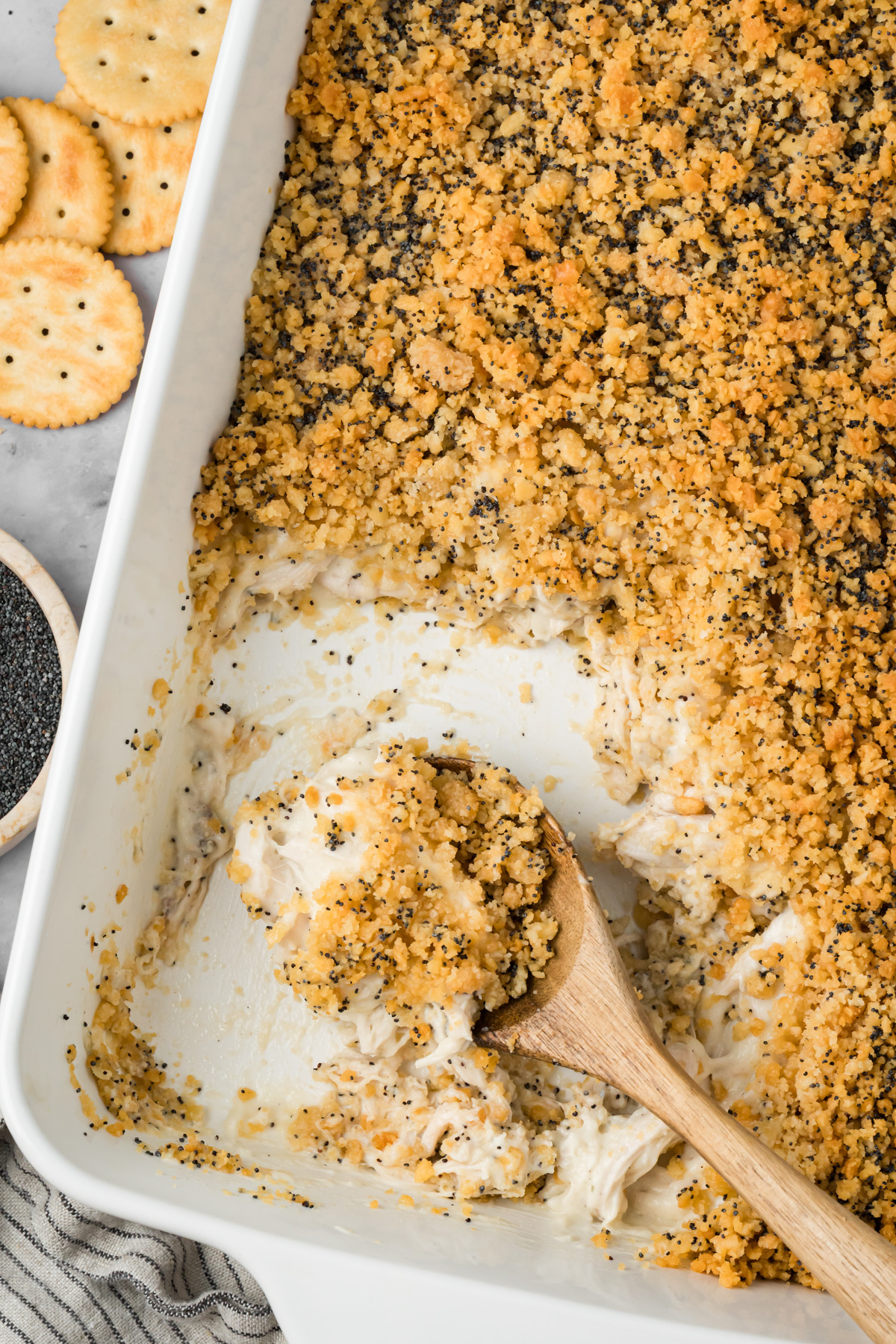 Baking dish filled with poppy seed chicken with a serving missing.