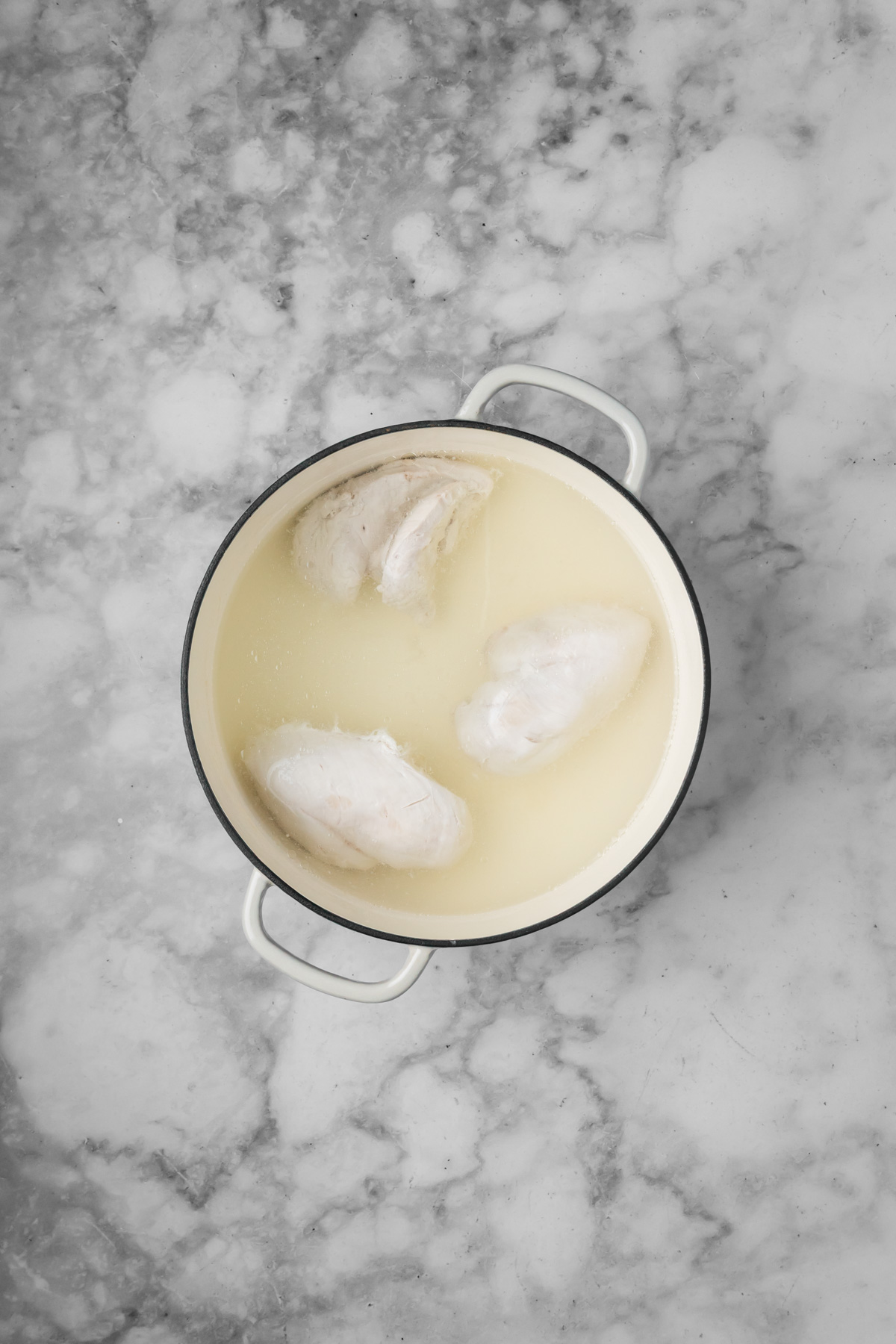 Chicken boiling in a pot.