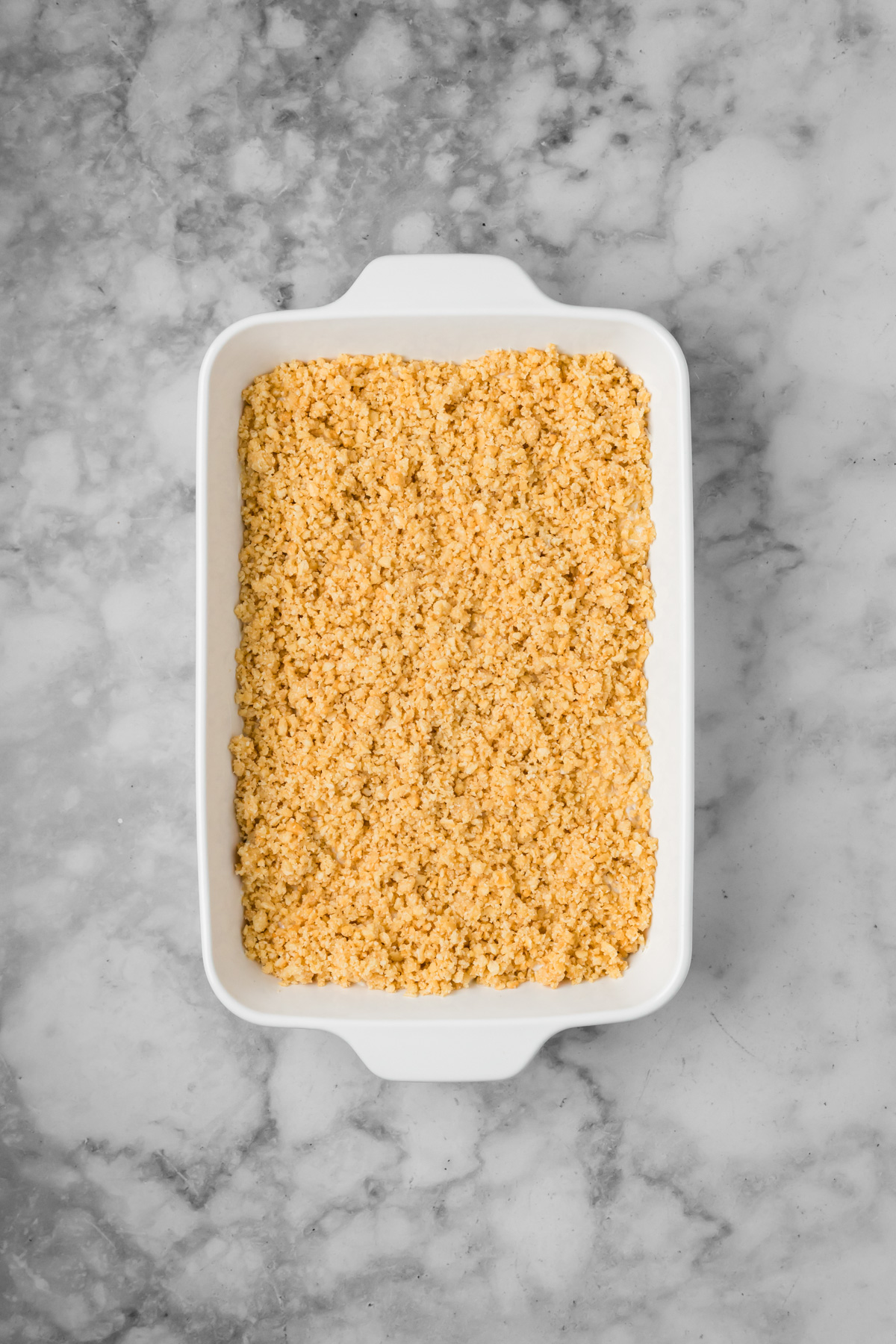 Buttery crackers added on top of the chicken mixture in the baking dish.