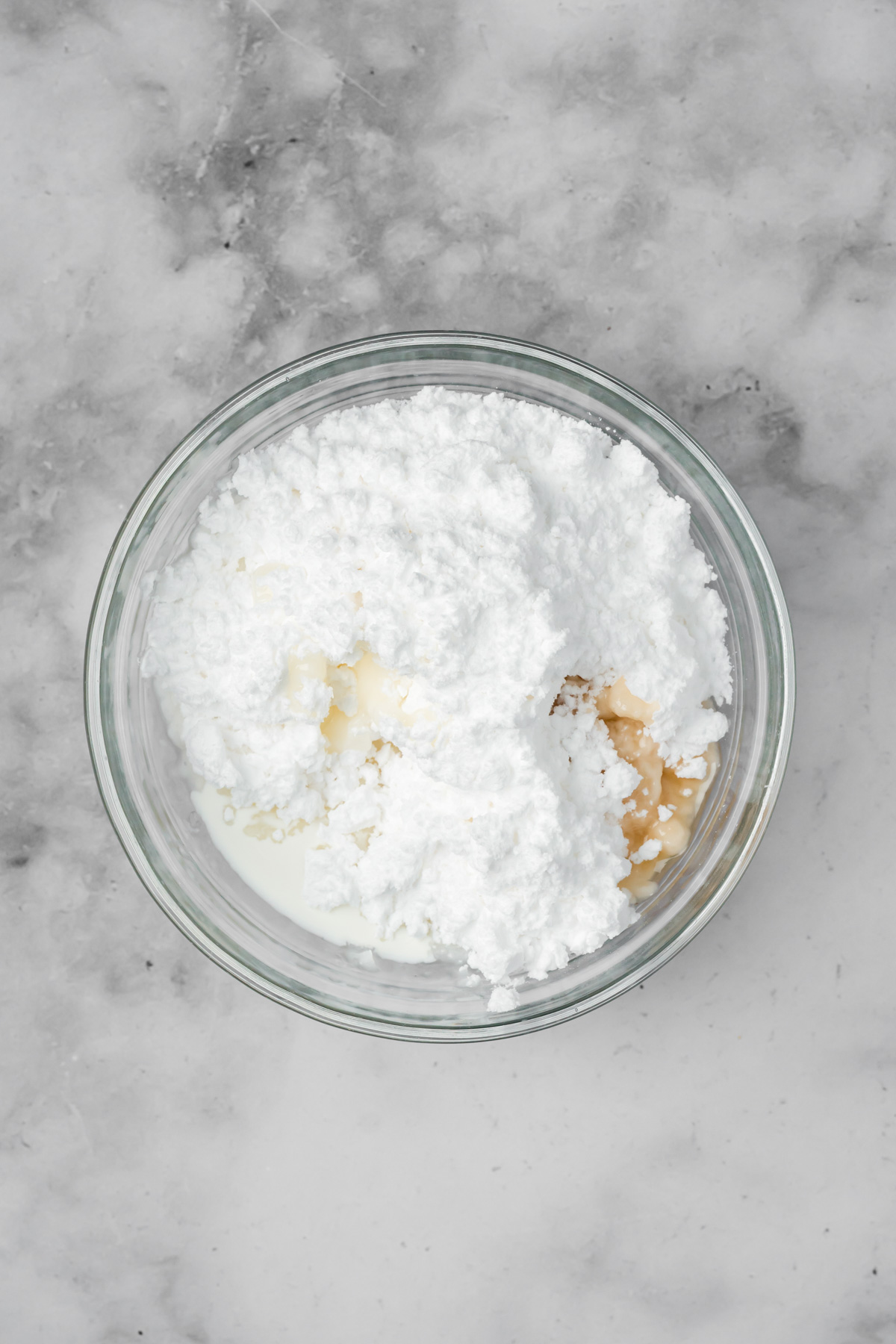 Ingredients for the frosting in a glass bowl.