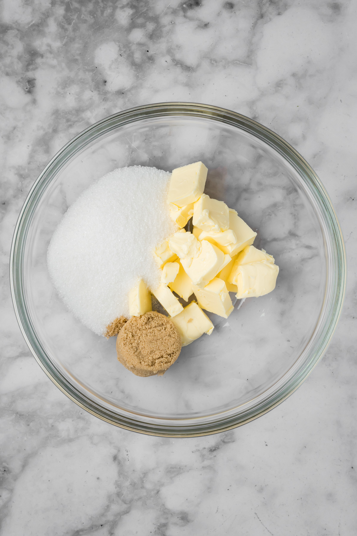 Butter and sugar in a glass bowl.