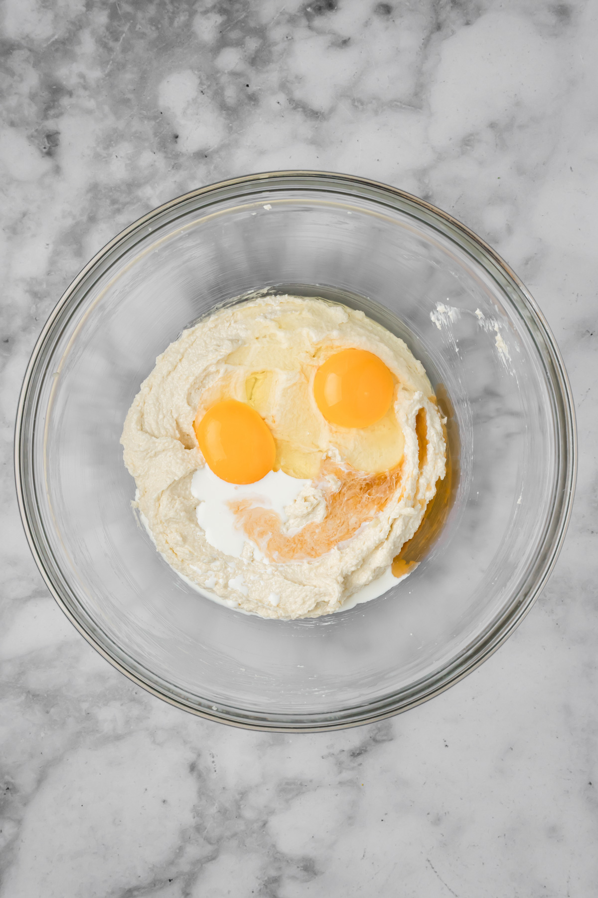 Eggs, half and half, and vanilla added into the glass bowl.