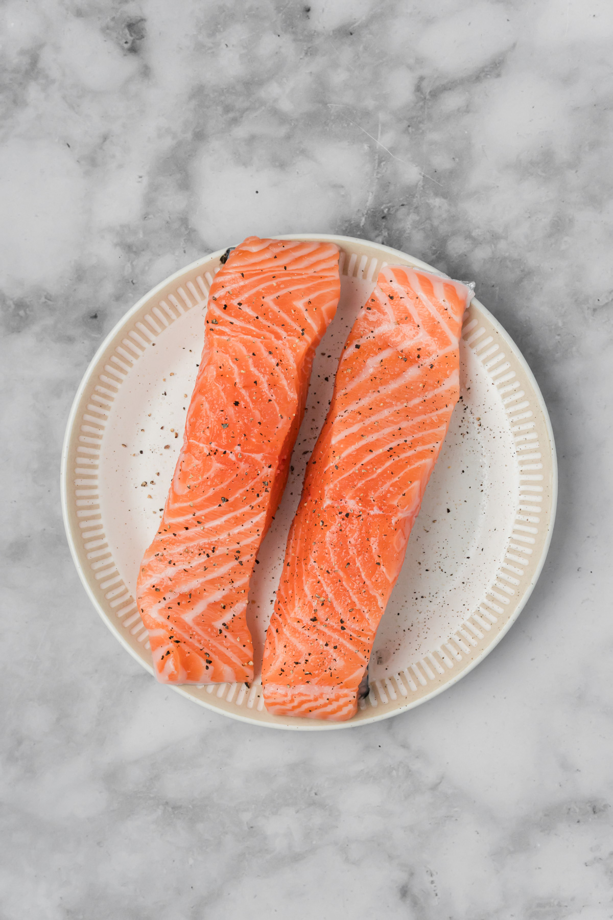 Salmon filets with salt and pepper on them. 