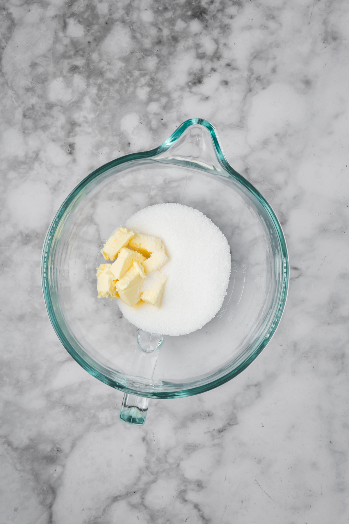 Butter and sugar in a glass bowl.