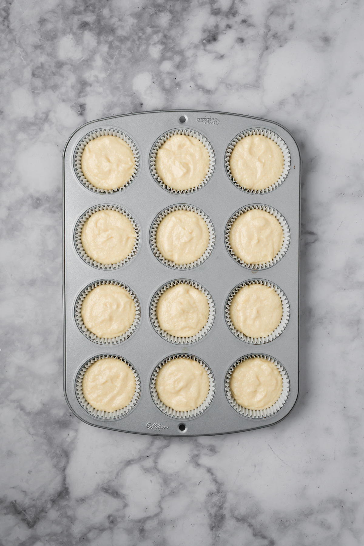 Muffin batter in muffin tin before baking. 